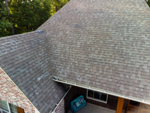 Residential roof showing hail damage, marked with chalk for roof inspection.